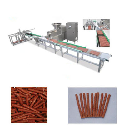 Το μασώντας σκυλί τσιμπά την κρύα μηχανή εξωθητών για τις λουρίδες κρέατος